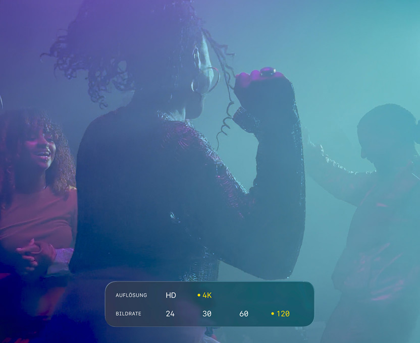 Ein Display mit drei tanzenden Personen, die bei wenig Licht gefilmt werden, zeigt die Möglichkeiten von 4K 120 fps Dolby Vision