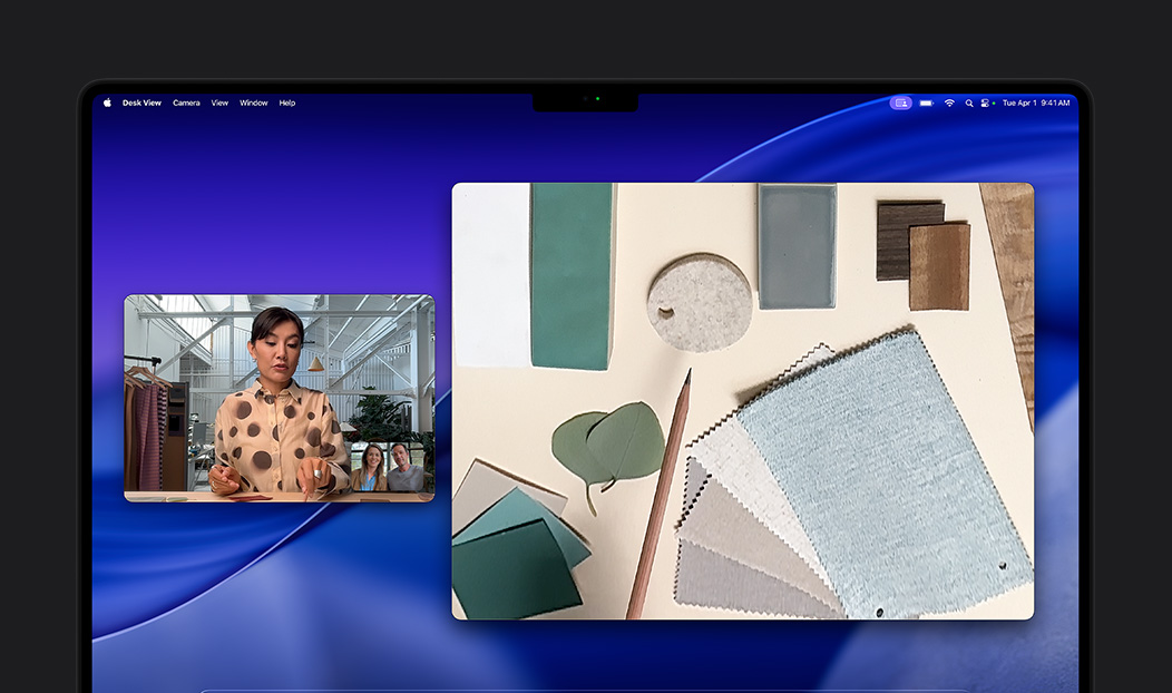 A video call on Macbook Pro of a woman using the Desk View feature to show her workspace filled with fabric squares to two people on the call, Desk View lets her show her workspace and her face simultaneously