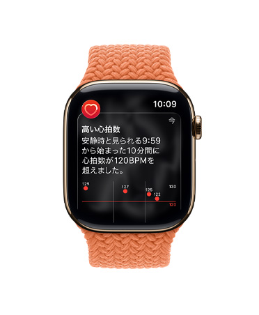 ゴールドチタニウムケースのApple Watch Series 11。高い心拍数の通知が表示され、ターメリックのブレイデッドソロループバンドが取りつけられている
