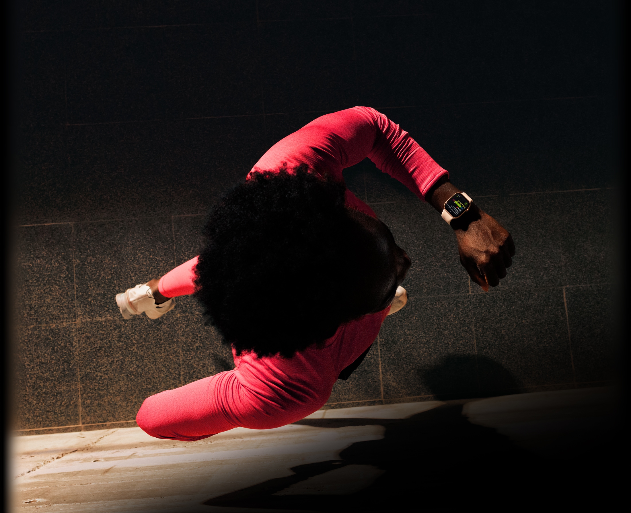 شخص يركض ويتحقق من التقدم في تطبيق التمرين على Apple Watch Series 11‏